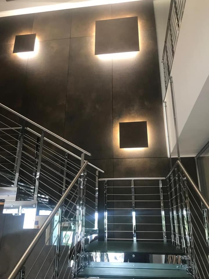 Scala interna con rivestimento scuro e illuminazione a parete