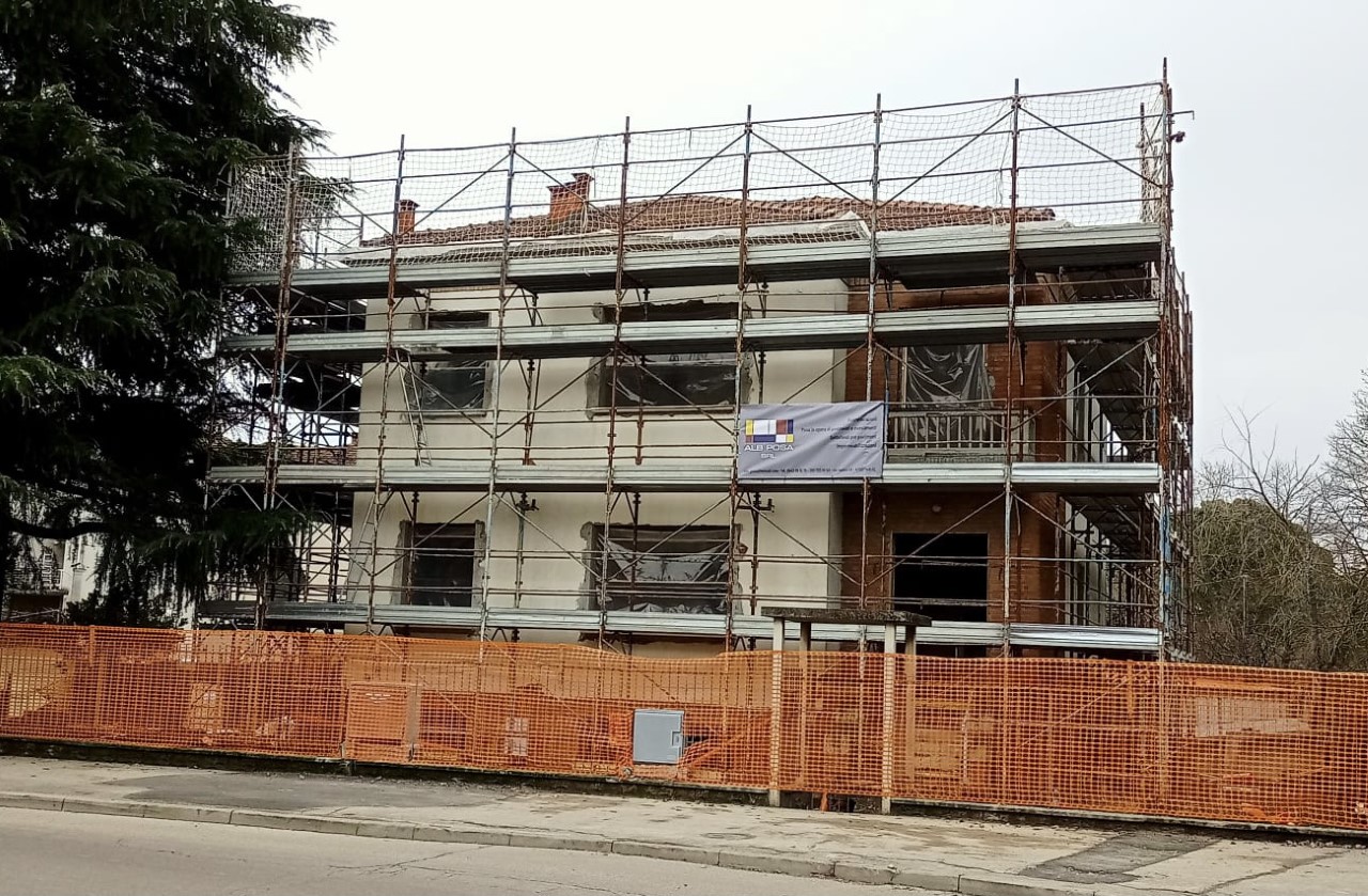 Edificio in lavorazione con ponteggi e cantiere protetto